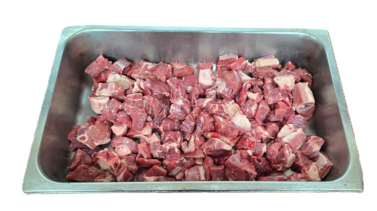 Fresh lamb curry pieces in a butcher's tray